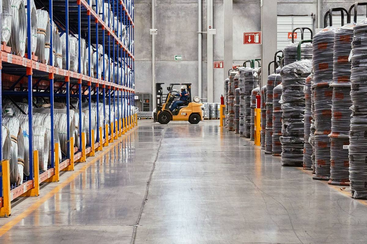 Tall warehouse shelving with a forklift working in the aisle